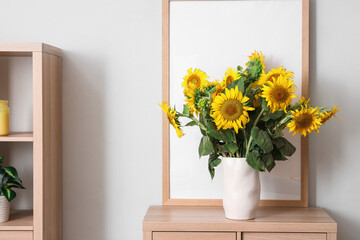 Vase of sunflowers bouquet on commode in living room, closeup