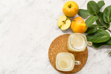 Mason jars of fresh apple kvass and fruits on white background