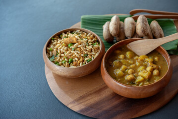 Mixed Indian food on wooden tray with three bowls of Muri rice,Dal soup, namkeen
