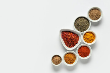 Bowls with fresh aromatic spices on light background
