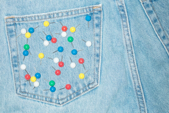 Blue denim jeans and colourful paper pins on the pocket and flash