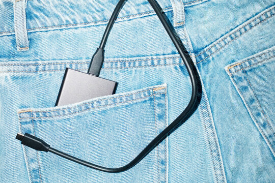 Harware device in pocket of blue denim jeans with hard direct flash
