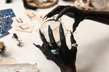 Bloody black witch hands with crystal ball and magic attributes on grunge white background....