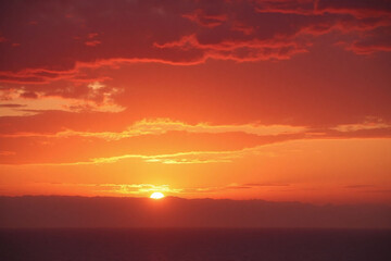 Obraz premium colorful sunset over the ocean with clouds in the sky