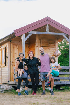 Happy Family Posing in Front of their Tiny House