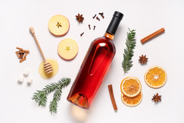 Bottle of tasty mulled wine and ingredients on white background