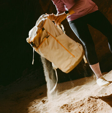 Woman putting on backpack in Buckskin Gulch