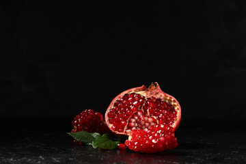Pieces of tasty fresh pomegranate on black background