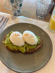 Poached eggs on toast with avocado, tomatoes and sprout for healthy breakfast. Vegetarian sandwiches. Toast bread. Smashed avocado. Luxury food. Egg benedict. Delicious fresh benedict egg. Bruschetta