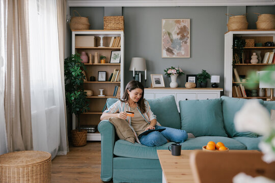 Young Woman Shopping Online Using a Digital Tablet and Credit Card