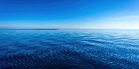 Fototapeta premium The ocean's vast expanse is mirrored by a cloudless sky above the water's surface, with the horizon blending seamlessly into the blue sea , cloudy sky, blue waters