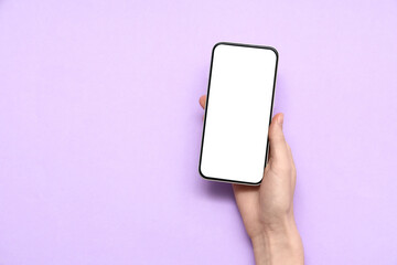 Female hand with mobile phone on purple background