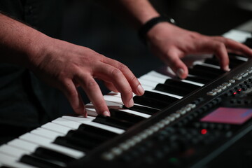 hands of a man playing the piano