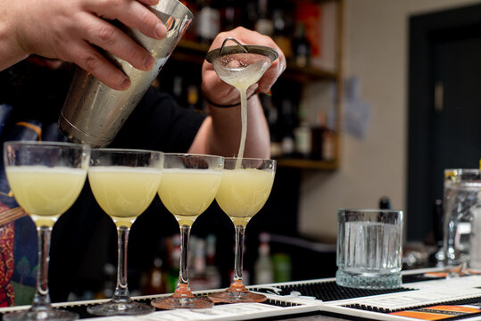 faceless Bartender prepares lemony cocktails at the bar counter