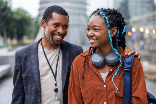 Smiling businessman spending leisure time with daughter in city 