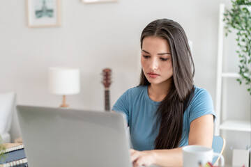 Depressed Asian woman freelancer using laptop device working in house.