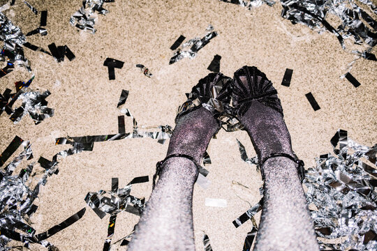 Feet in shiny black shoes and glitter on the dance floor