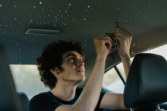 A teenage boy installs Starlights in his car