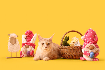 Cute Maine Coon cat with Easter basket and toys on yellow background
