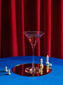 Elegant Martini Glass on Reflective Surface with Chess Pieces