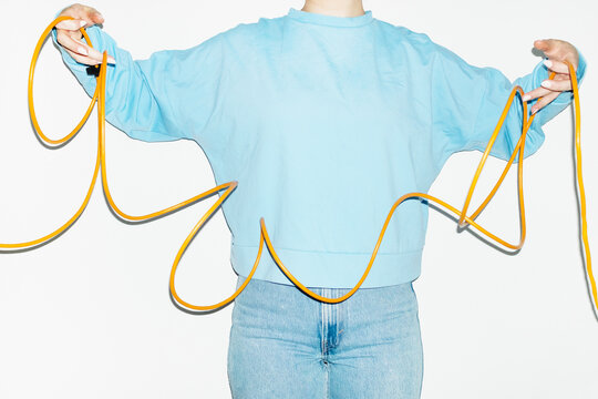 Person holding a curvy electronic tech wire with hard direct flash