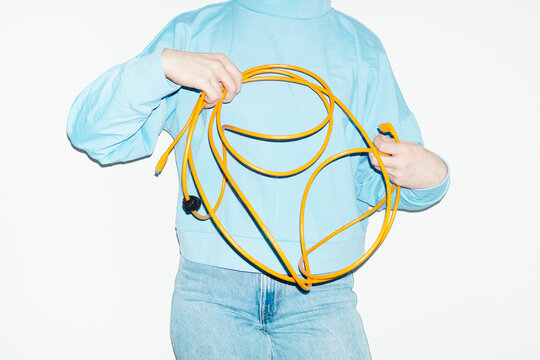 Person holding a curvy electronic tech wire with hard direct flash