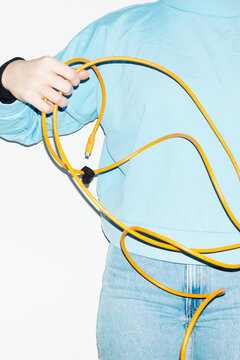 Person holding a curvy electronic tech wire with hard direct flash