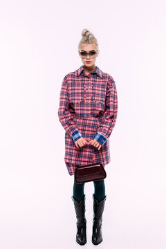 Stylish model showcases trendy plaid outfit with sunglasses