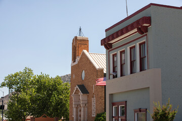 Afternoon sun shines on a historic church and downtown facade of the Warren neighborhood of Bisbee, Arizona, USA.