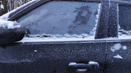 Frost covers car window in a winter morning setting