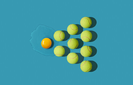 Collection of yellow tennis balls arranged around broken egg yolk