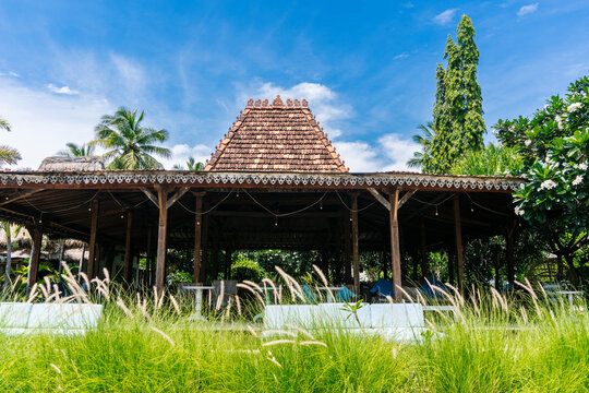 Traditional Indonesian gazebo with tiled roof surrounded by greenery