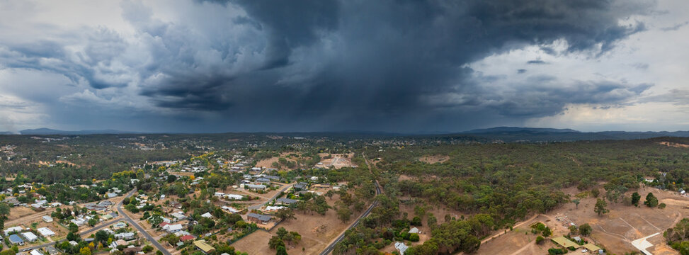 Rain falling from storm clouds over country town