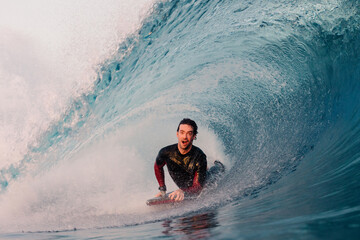 A professional bodyboarder doing a tube on a big wave