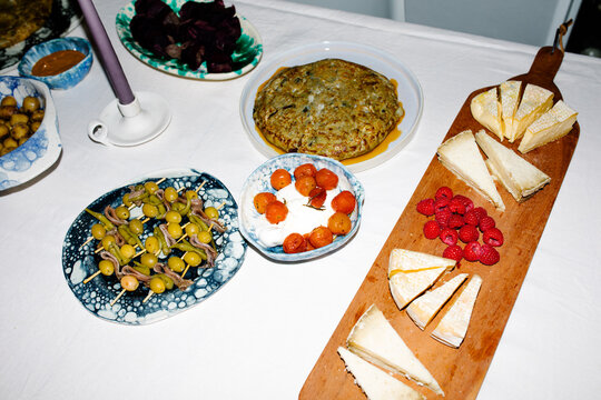 Detail of a cheese board placed on a table with more Spanish snalcks
