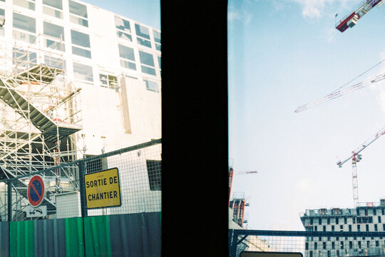 Construction site with cranes and scaffolding under bright sky