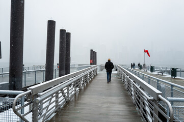 Man Walking on Snowy Pier
