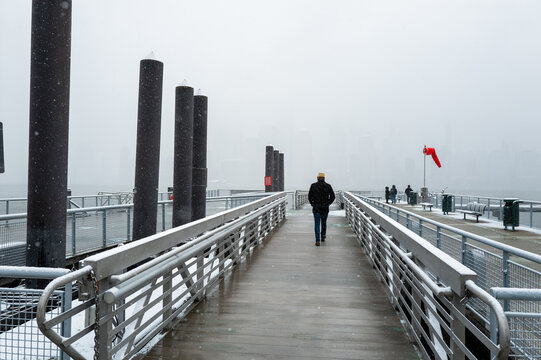 Fototapeta Man Walking on Snowy Pier