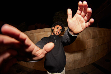 Man showing hands to camera in street in dark place