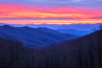 Serene sunrise paints vibrant hues across layered mountain ranges, showcasing a breathtaking natural landscape.