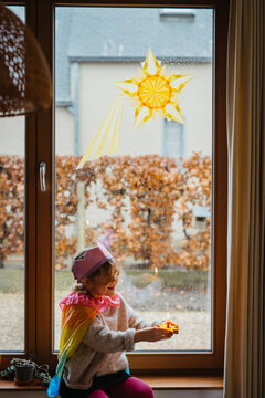 child with colorful cape under rainy day window sun art for Epiphany