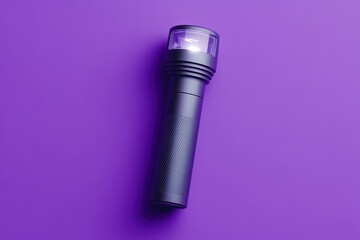 A single dark colored flashlight with the light turned on