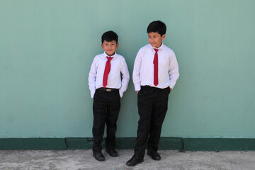 8 and 10 year old Latino children dressed in school uniforms are happy and excited about going back...