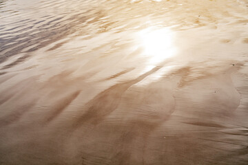 
golden reflections on the beach sand