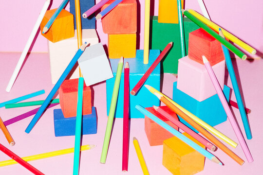 Colourful building blocks cubes on pink background with hard flash