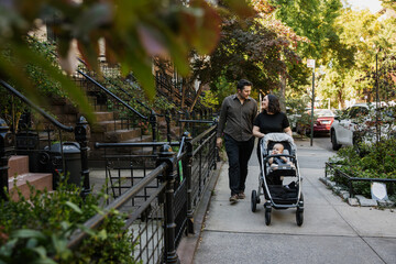 Family Strolling Through a Neighborhood With Stroller On a Sunny Day