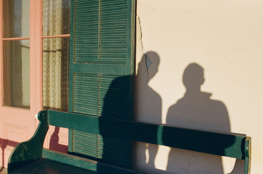 A couple's shadows cast on a white adobe wall