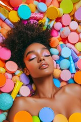 A woman is laying in a pile of colorful makeup products