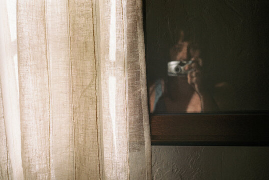 Shadowed reflection behind textured linen curtain