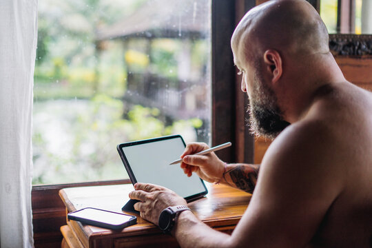Digital nomad working remotely from Bali with tablet and stylus